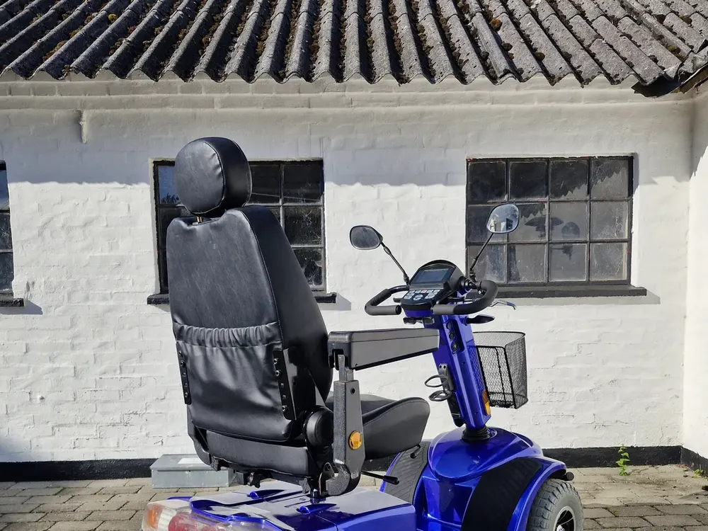 Blå firehjulet elscooter med højt ryglæn set bagfra – handicapscooter