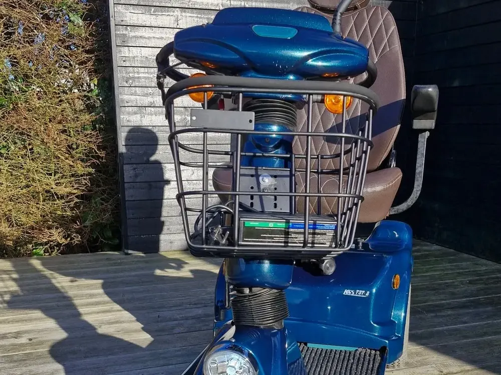 Blå trehjulet elscooter med kurv set forfra, renoveret på HalleCares værksted – handicapscooter