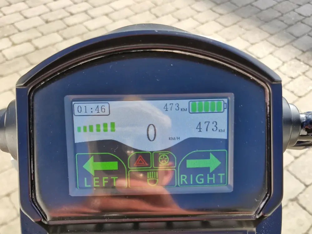 Display med hastighed, batteriniveau og kilometertæller på en elscooter – handicapscooter