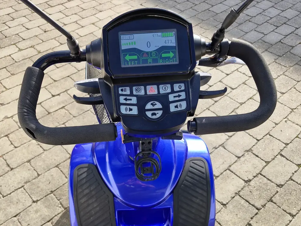 Styr og display på en blå firehjulet elscooter – handicapscooter