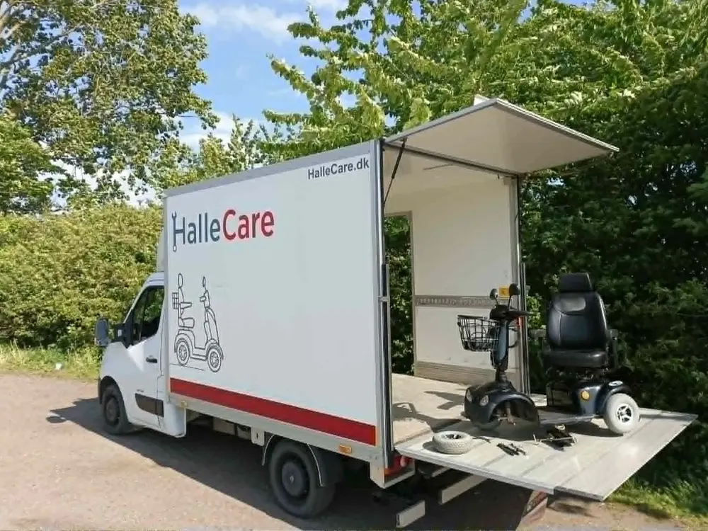 HalleCares mobile værksted med åben bagklap og en elscooter på liften – handicapscooter